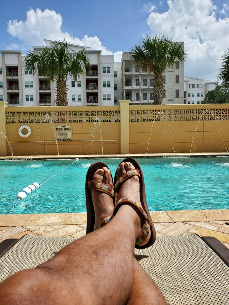 Casual poolside view with sandals in tropical Orlando setting under clear skies.